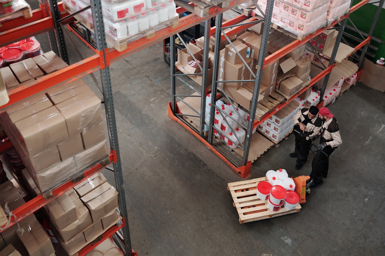 home-hero Workers managing inventory on shelves in a warehouse, viewed from above.