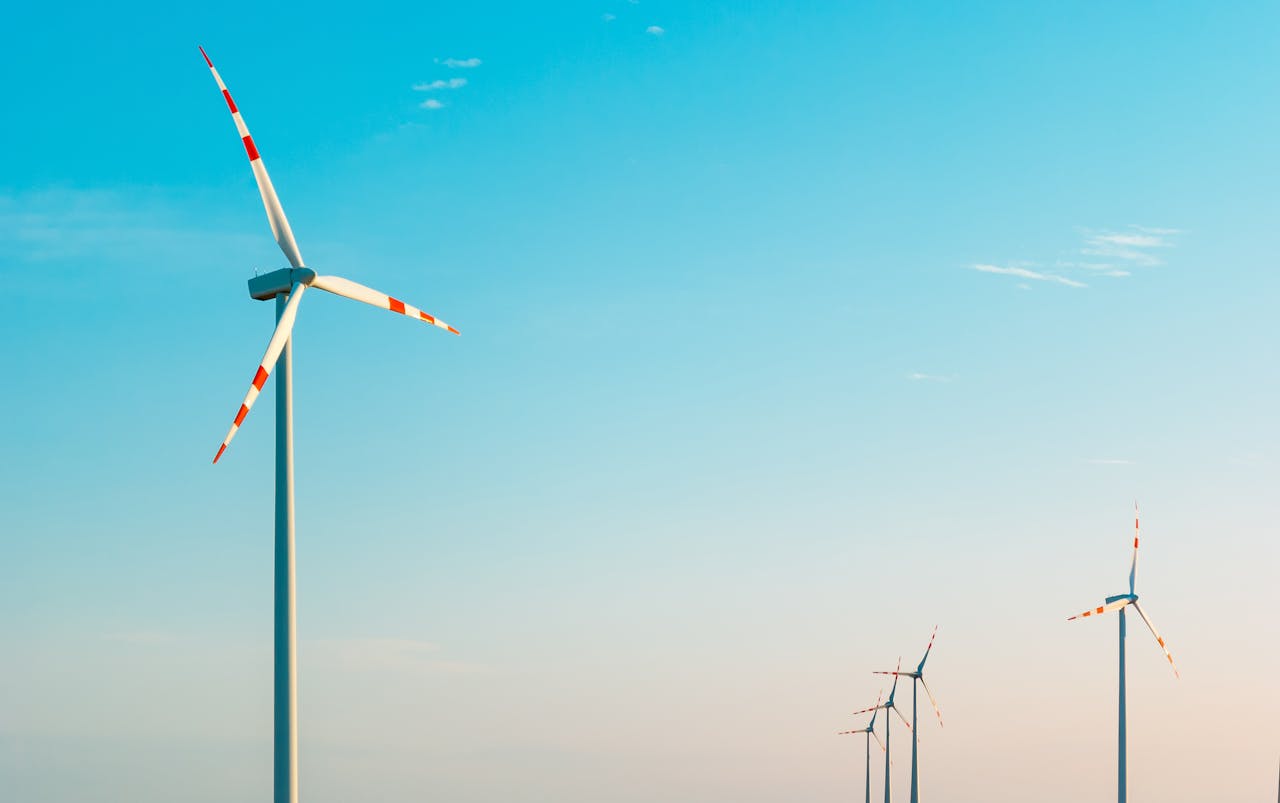 services-05 A serene image of wind turbines against a bright blue sky, symbolizing sustainable energy.